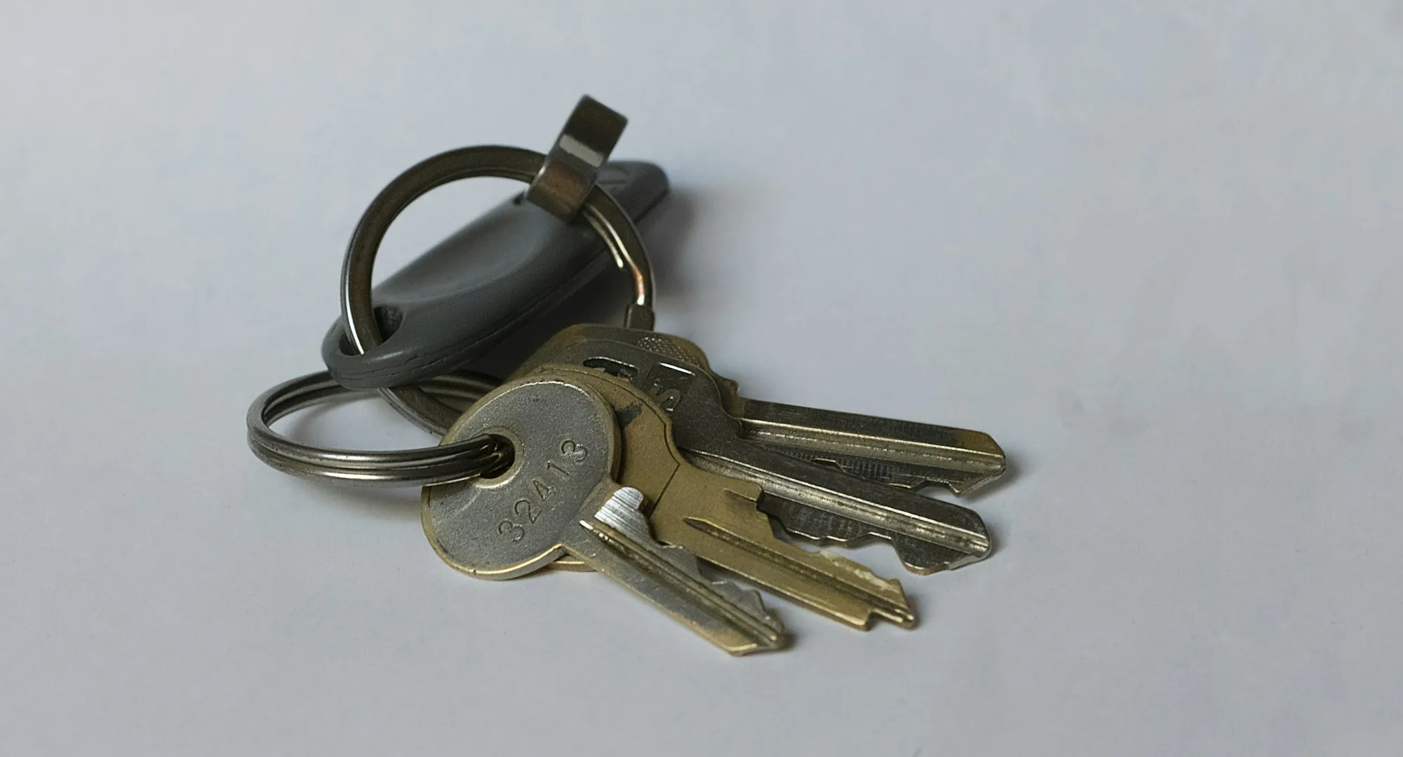 Set of house keys on a key ring lying on a gray surface
