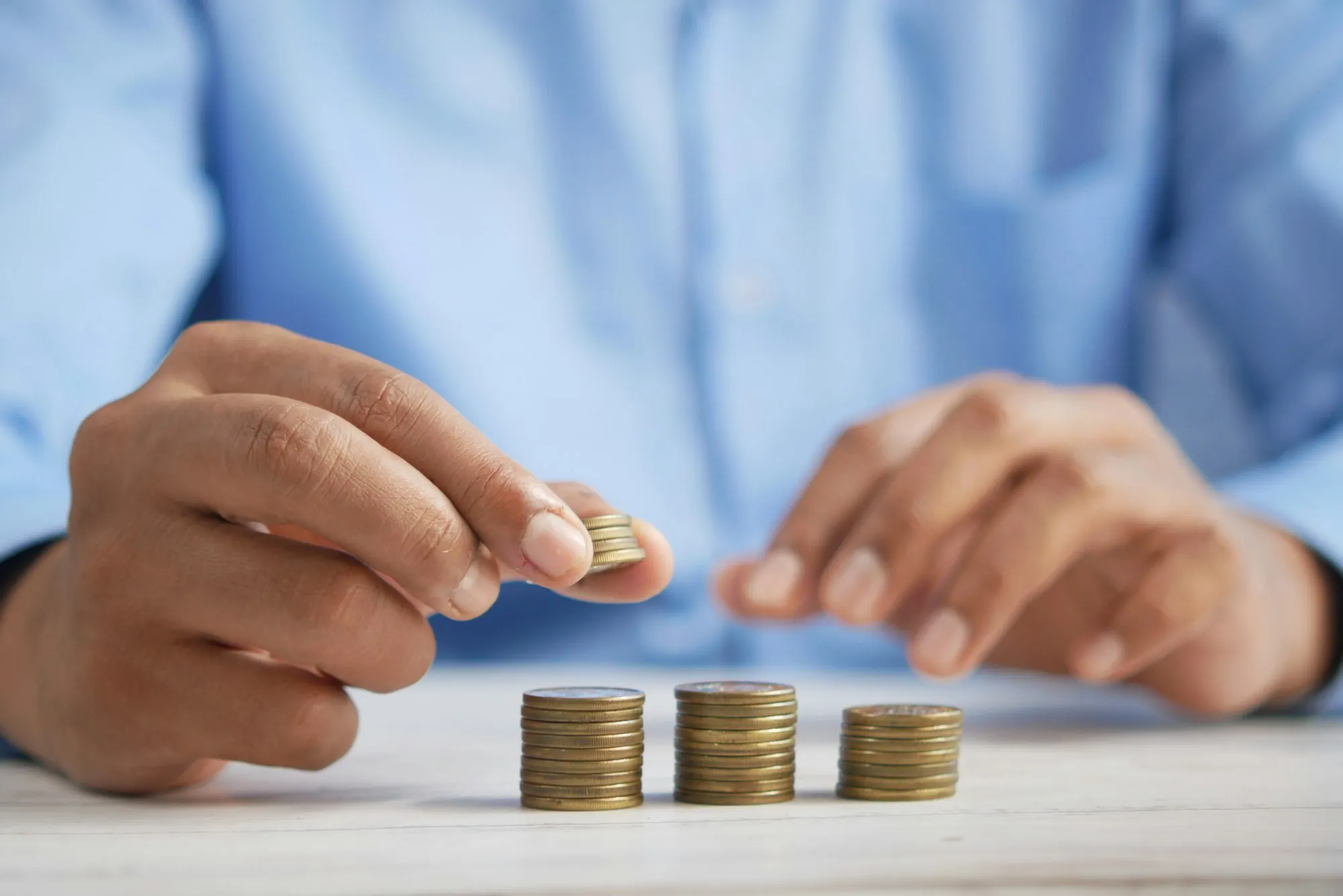 Hands stacking coins on a desk